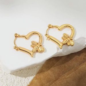 Elegant 18K gold heart-shaped hoop earrings with detailed bee motif on white stone