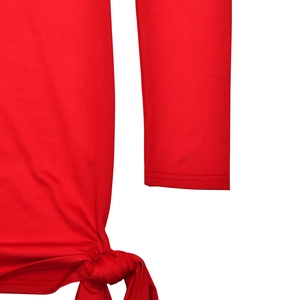 Detail view of red slim fit dress featuring a side knot hem and smooth elastic fabric texture