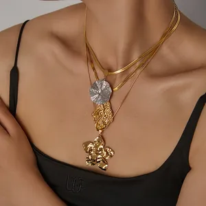 Detail of layered gold titanium necklace featuring a wrinkled flower petal pendant