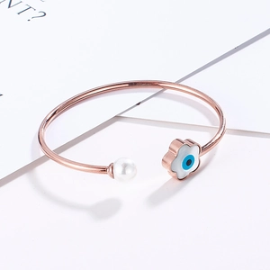 Detailed macro view of the rose gold evil eye and pearl open cuff bracelet details