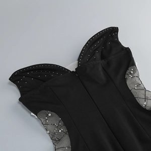 Detail of black dress featuring sheer mesh panels with silver sequins and white pearls