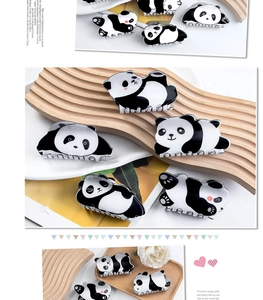Detailed view of cute panda hair claws on a wooden tray with glossy finish and panda shape