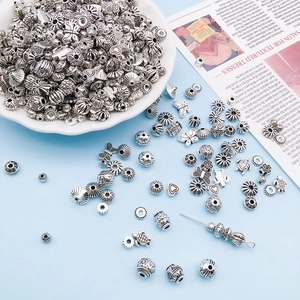 Antique silver alloy charms for DIY jewelry making in various shapes on blue background