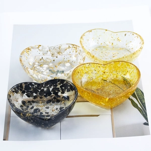 Four heart-shaped resin jewelry dishes with assorted natural stone chips and gold foil