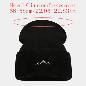Detail of mountain embroidery on a black knit beanie with head circumference dimensions