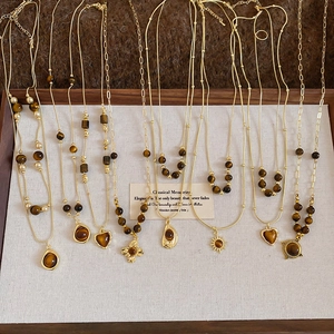 Detailed close-up of multiple vintage tiger eye flower pendants on golden necklaces