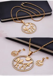 Close-up of golden bird and moon pendant necklace set with sparkling crystal stones