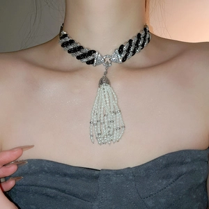 Detail of luxury choker featuring zircon chain and elegant white pearl tassels