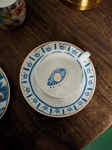 Top view of ceramic teacup and saucer with blue evil eye pattern and gold gilding