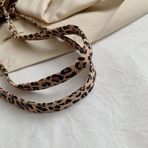 Macro detail of high-quality leopard print strap on a stylish canvas tote bag