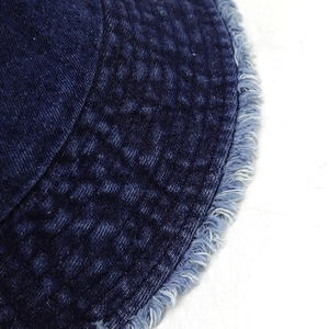 Gros plan d'un bob en jean bleu foncé avec des bords effilochés et des coutures précises