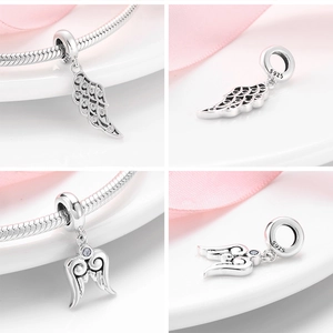 Detailed view of S925 sterling silver angel wing charms with sparkling crystal accents