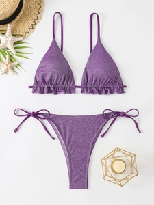 Détail du bikini violet à volants avec texture scintillante et accessoires de vacances