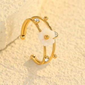 Macro shot of double-layered 18K gold ring with white flower and sparkling cubic zirconia