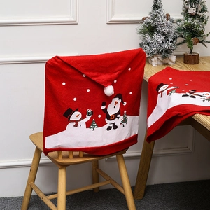 Detail of red Santa hat chair covers and matching festive table runner for Christmas party