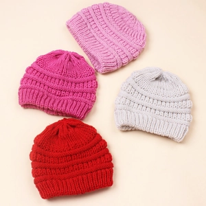 Flat lay of ribbed knit baby hats in pink, grey, and red for autumn winter warmth