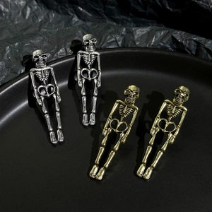 Macro detail of gothic skull earrings in vintage gold and silver alloy finish