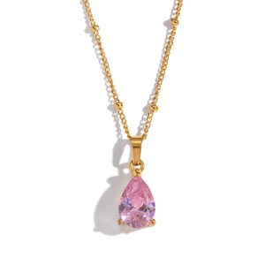 Detail of pink pear-cut zircon pendant on gold beaded chain necklace with claw setting