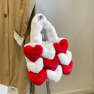 Detailed view of red and white plush heart-shaped tote bag hanging on a metal rod