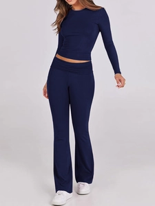 Dettaglio del crop top blu scuro a maniche lunghe e pantaloni in maglia a vita alta a zampa