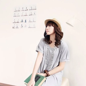 Detail of a gray short-sleeved V-neck dress paired with a straw fedora and pearl necklace