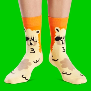 Detail of cotton crew sock featuring a cartoon alpaca with sunglasses and orange cuff