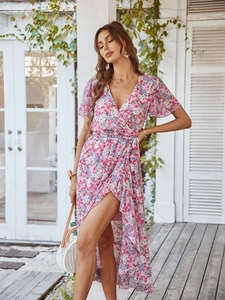 Robe longue fleurie avec col en V et taille nouée portée par un mannequin en extérieur