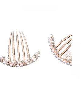 Detailed macro view of rose gold alloy hair comb with white pearls and sparkling rhinestones