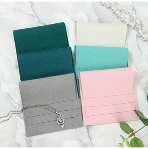 Microfiber jewelry pouches in five premium colors stacked on marble background