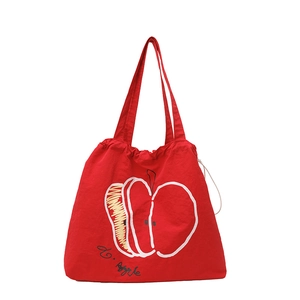 Minimalist red drawstring canvas tote bag with artistic white apple print and slim straps