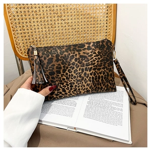 Detailed close-up of leopard print envelope bag with trendy tassel zipper and wrist strap