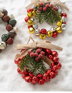 Detailed Christmas bell wreath featuring rustic burlap bow and festive pine needle accents