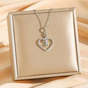 Collier serpent en forme de cœur argenté avec zircons sur un coffret à bijoux doré
