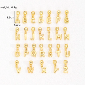Macro shot of gold-plated 26-letter bubble charms with dimensions 1.5cm by 0.6cm