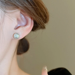 Close-up of elegant minimalist 8-10mm grey pearl stud earrings worn by a model