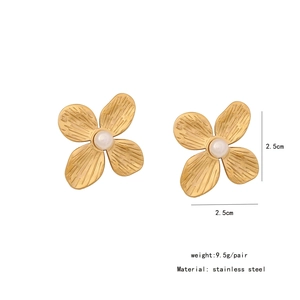 Detail of gold clover flower stud earrings with white pearl and stainless steel specs