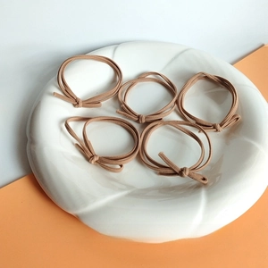5-piece set of high elasticity brown hair ties with knot detail on ceramic plate