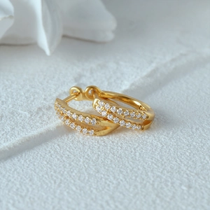Macro detail of gold hoop earrings with double row micro-pave cubic zirconia crystals