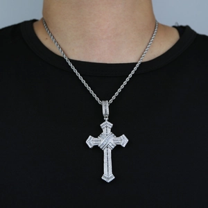 Detail of silver cross pendant with white zircons on a twist chain worn by a model