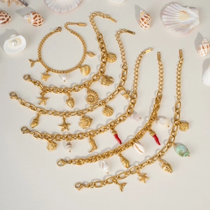 Detail view of gold ocean-themed charm bracelets with starfish and shell pendants
