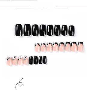 Detailed close-up of black and white French press-on nails with silver glitter wavy lines