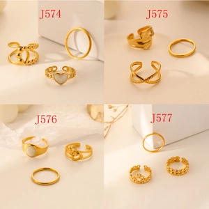 Close-up of four gold stainless steel ring sets with heart shell and twisted textures