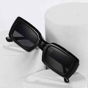 Minimalist black rectangular sunglasses on white display stands with modern sleek design