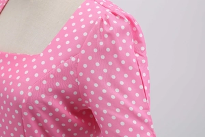 Detail of pink polka dot dress showing pleated shoulder and square neckline on mannequin