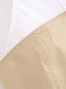 Détail du tissu en coton sergé kaki avec surpiqûres blanches et finitions soignées
