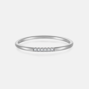 Macro shot of silver ring with six brilliant-cut diamonds in a minimalist row