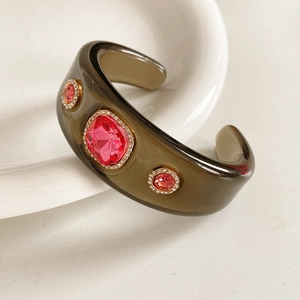 Macro detail of vintage resin cuff bangle with pink crystals and sparkling rhinestone halo