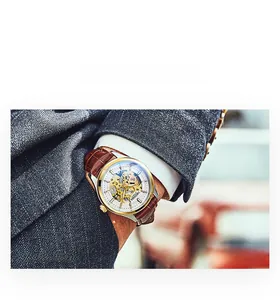 Business man wearing a luxury skeleton mechanical watch with brown leather strap and gold case