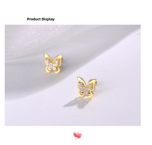Macro detail of gold-plated silver butterfly stud earrings with sparkling crystals