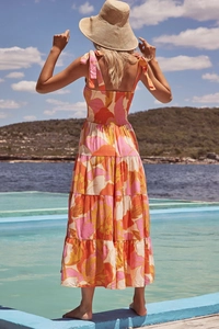 Floral maxi dress with tie-shoulder straps and layered hem in a summer vacation setting